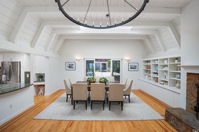 dining space with a fireplace, wood ceiling, light wood-style flooring, and vaulted ceiling with beams