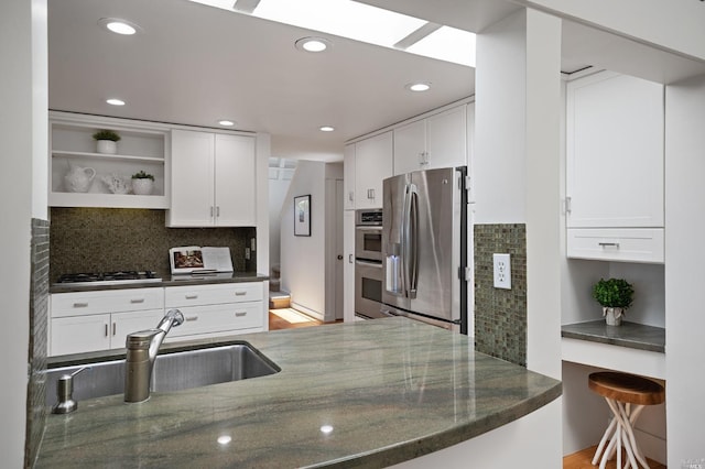 kitchen with open shelves, white cabinets, appliances with stainless steel finishes, and a sink