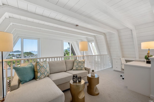 living area with beam ceiling, a healthy amount of sunlight, and carpet floors