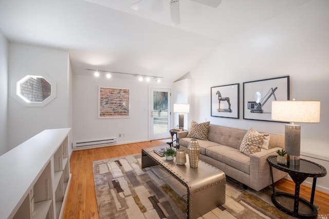 living area with light wood-style floors, baseboard heating, track lighting, and vaulted ceiling