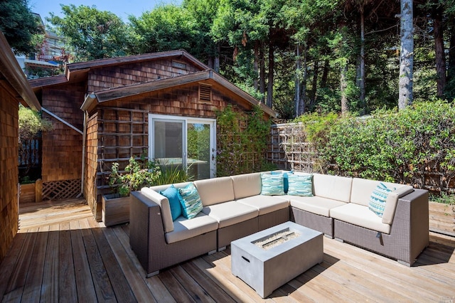 wooden deck featuring an outdoor living space with a fire pit