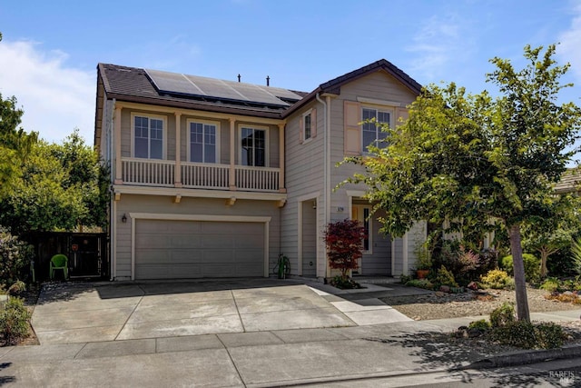 view of front of property with solar panels, driveway, a garage, and fence