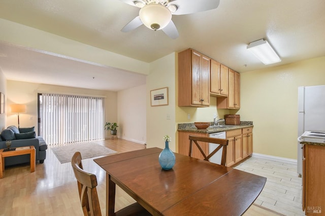 dining space with a ceiling fan, light wood-style floors, and baseboards