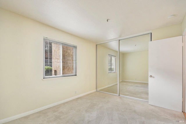 unfurnished bedroom with baseboards, a closet, and carpet floors