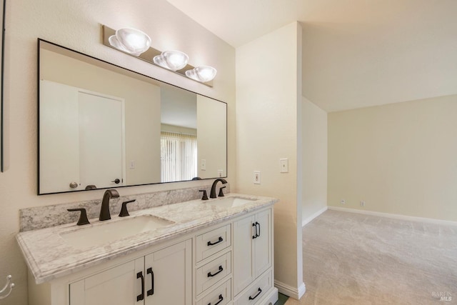 bathroom with a sink, baseboards, and double vanity