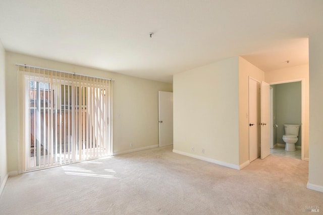 empty room with light carpet and baseboards