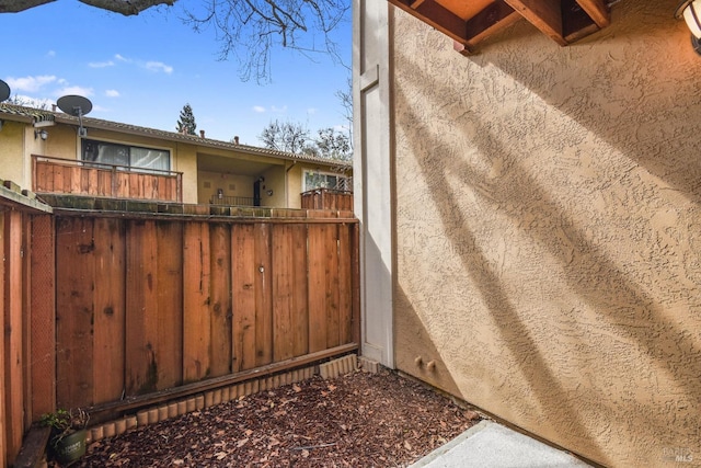 view of property exterior with stucco siding and fence