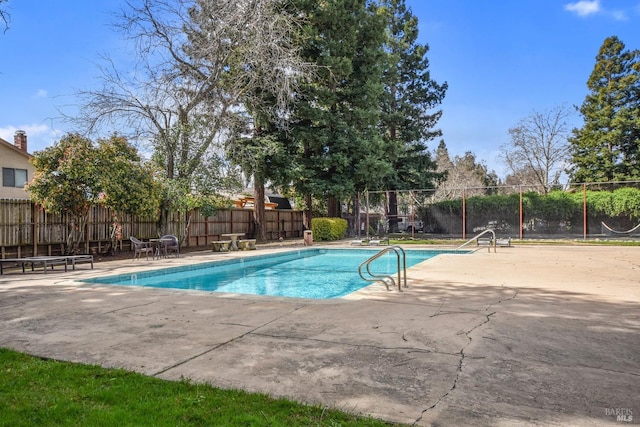 view of swimming pool featuring a fenced in pool, fence, and a patio area