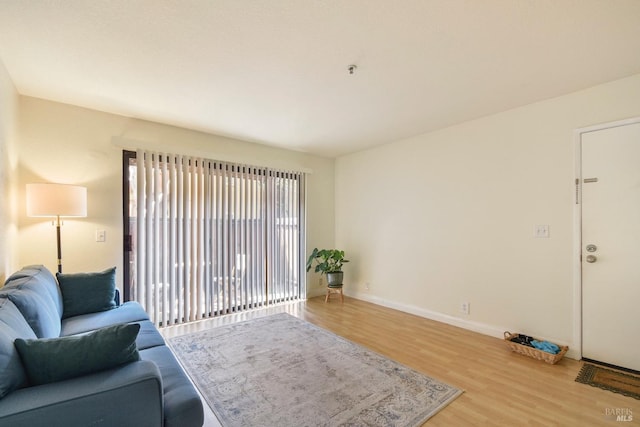 living area with light wood-style flooring and baseboards