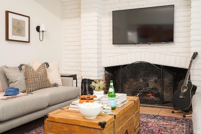 tiled living room featuring a brick fireplace