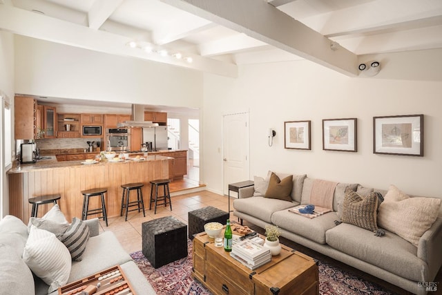 living room with light tile patterned floors and vaulted ceiling with beams