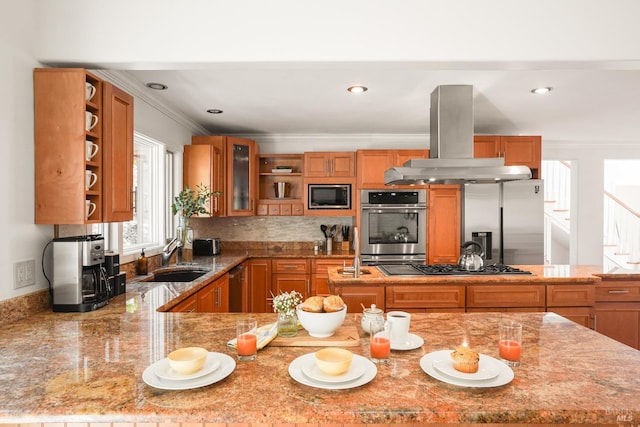 kitchen with brown cabinetry, open shelves, island exhaust hood, a sink, and stainless steel appliances