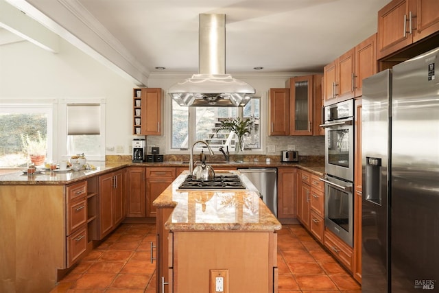 kitchen with island exhaust hood, appliances with stainless steel finishes, a peninsula, and crown molding