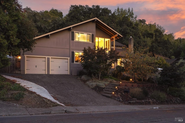 view of front facade featuring aphalt driveway and fence