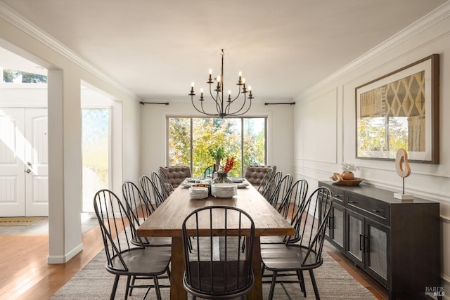 dining space featuring a chandelier, dark wood-style flooring, and ornamental molding