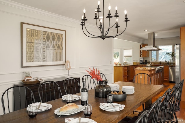 dining room featuring a decorative wall, dark wood-style flooring, a chandelier, and ornamental molding