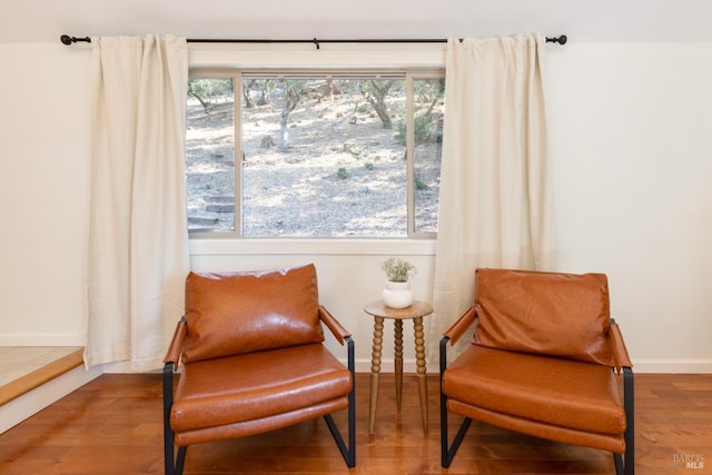 sitting room with baseboards and wood finished floors