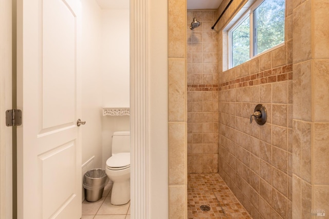 bathroom featuring tile patterned floors, toilet, and tiled shower