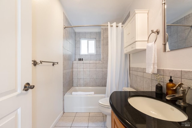 bathroom featuring tile walls, toilet, tile patterned floors, vanity, and shower / bathtub combination with curtain