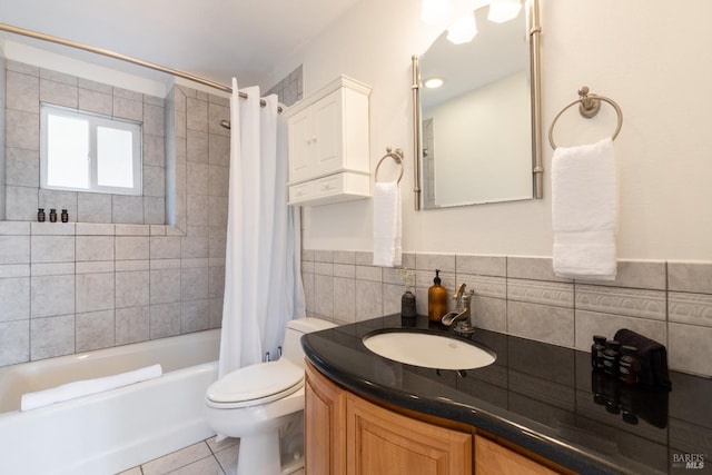 full bath with vanity, shower / bathtub combination with curtain, tile patterned flooring, tile walls, and toilet