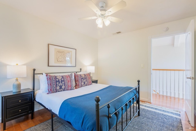 bedroom with baseboards, wood finished floors, visible vents, and ceiling fan