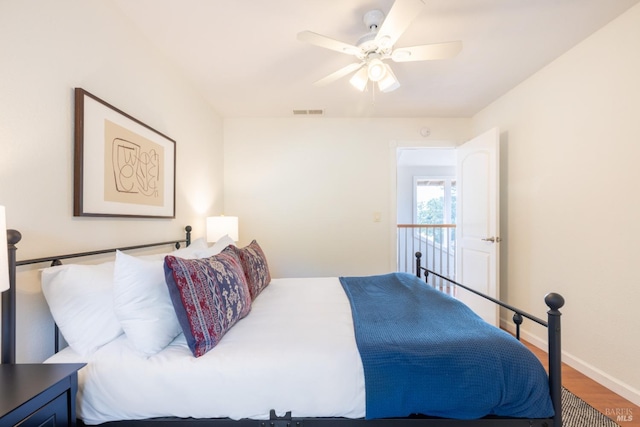 bedroom with visible vents, wood finished floors, baseboards, and ceiling fan