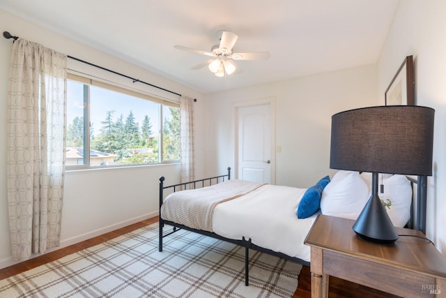 bedroom with a ceiling fan, baseboards, and light wood finished floors