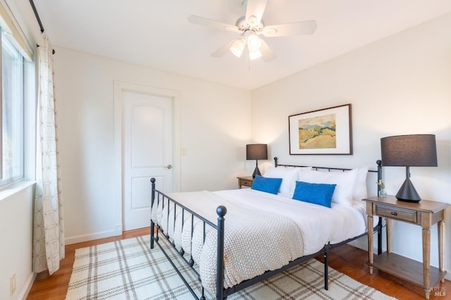 bedroom with ceiling fan, baseboards, and wood finished floors