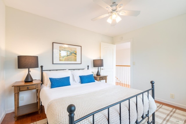 bedroom with baseboards, wood finished floors, and a ceiling fan