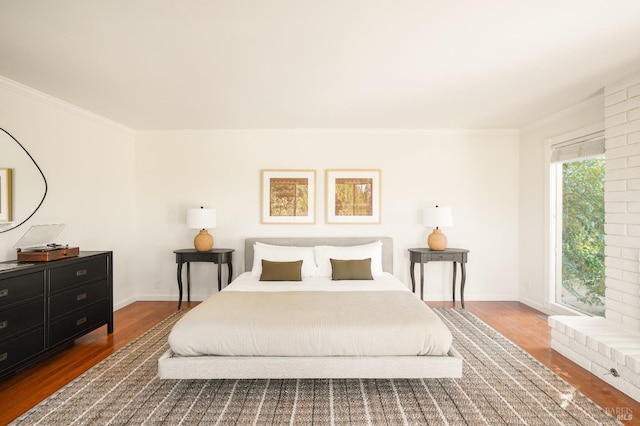 bedroom featuring crown molding, wood finished floors, and baseboards