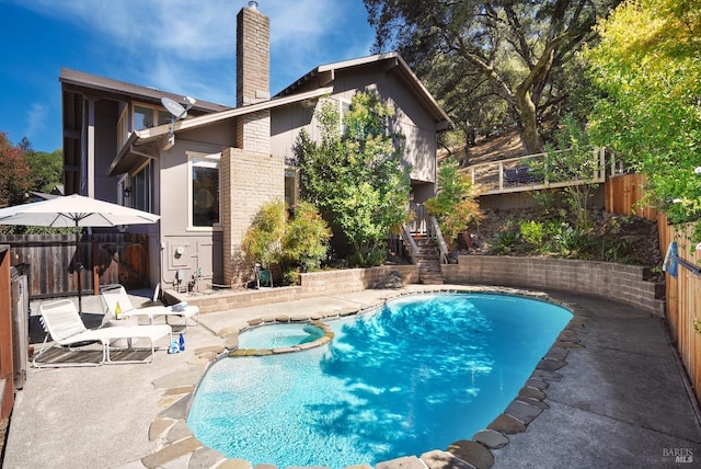 view of swimming pool featuring a fenced backyard, a pool with connected hot tub, stairs, and a patio