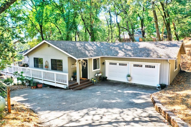 ranch-style home with a garage, a porch, driveway, and roof with shingles