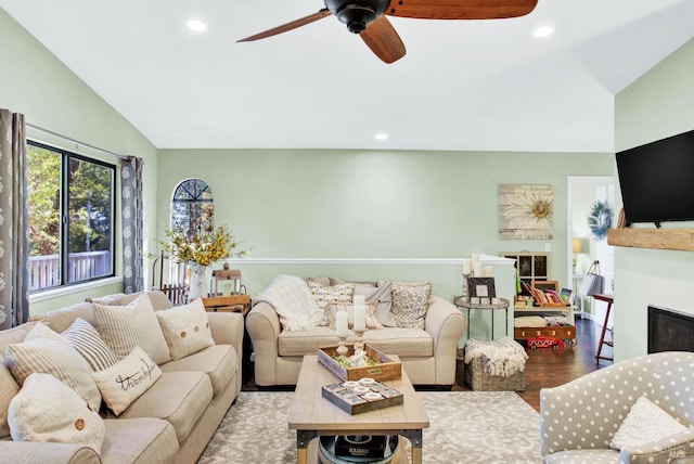 living area with ceiling fan, lofted ceiling, recessed lighting, wood finished floors, and a glass covered fireplace