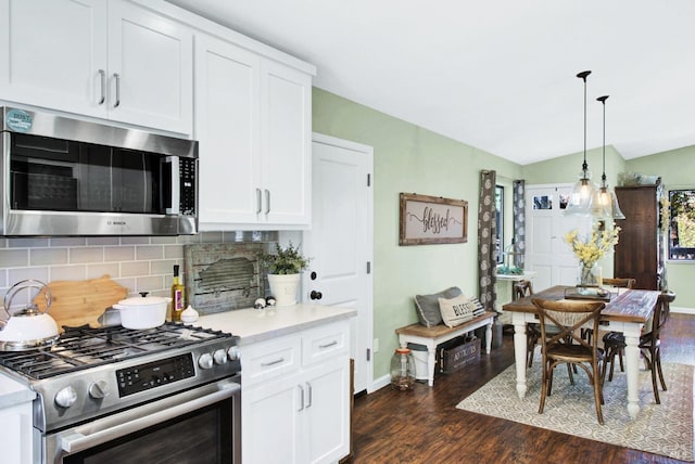 kitchen featuring tasteful backsplash, dark wood finished floors, pendant lighting, stainless steel appliances, and white cabinetry