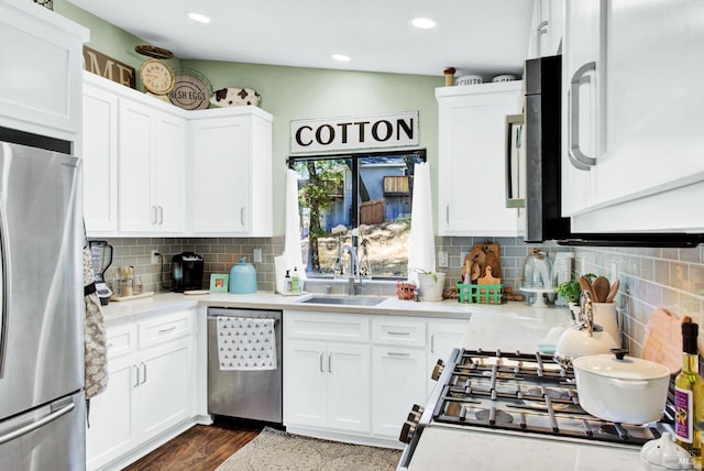 kitchen with a sink, appliances with stainless steel finishes, white cabinets, and light countertops