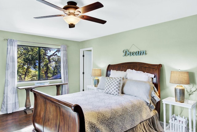 bedroom featuring dark wood finished floors, a ceiling fan, and baseboards