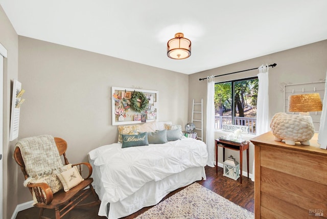 bedroom with baseboards and wood finished floors