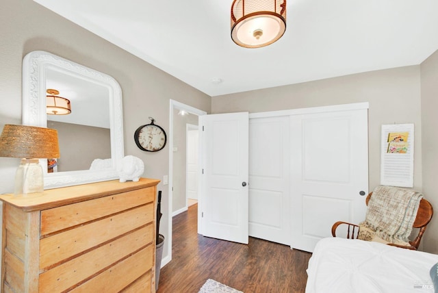 bedroom with a closet, baseboards, and dark wood-style flooring