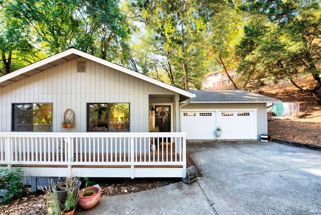 ranch-style house featuring concrete driveway, a garage, and roof with shingles