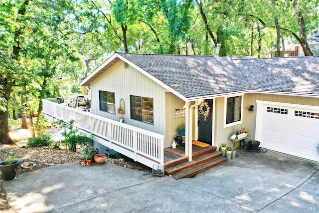 ranch-style home featuring a porch, concrete driveway, roof with shingles, and an attached garage