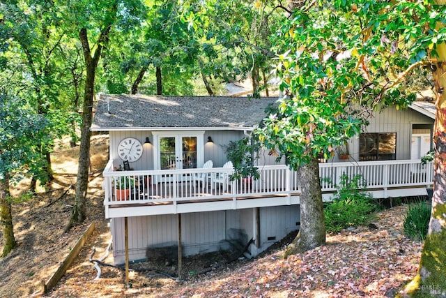 rear view of house featuring a shingled roof