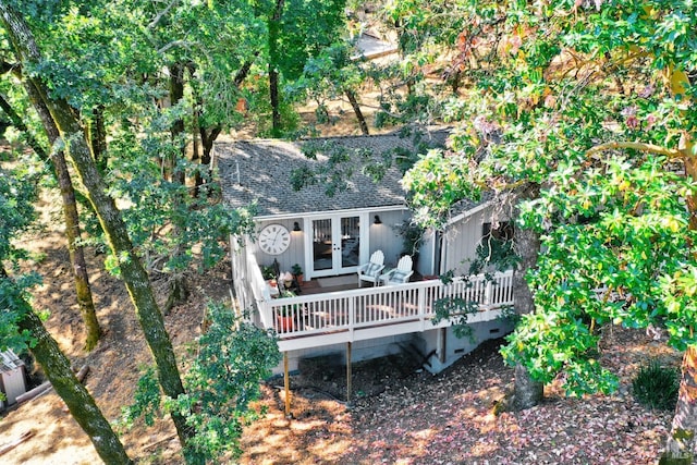 rear view of property featuring french doors, roof with shingles, and a deck