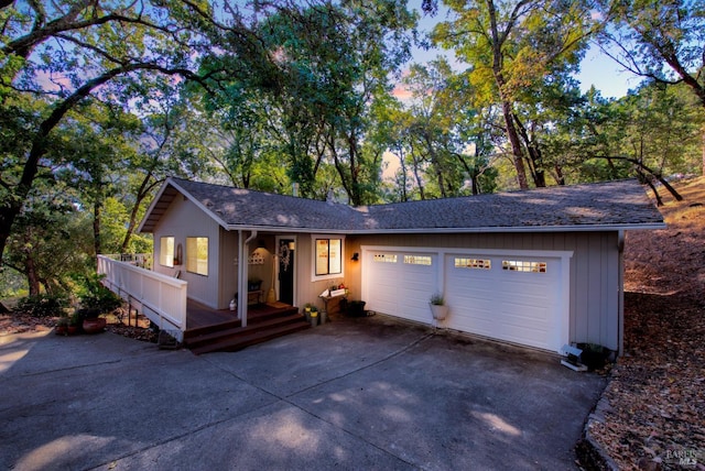 ranch-style home with concrete driveway, an attached garage, and a shingled roof