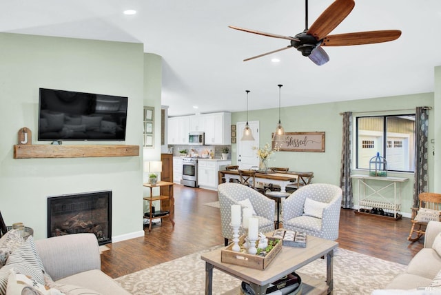 living room with recessed lighting, a fireplace, baseboards, ceiling fan, and dark wood-style flooring