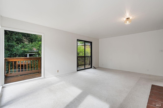 carpeted empty room featuring baseboards