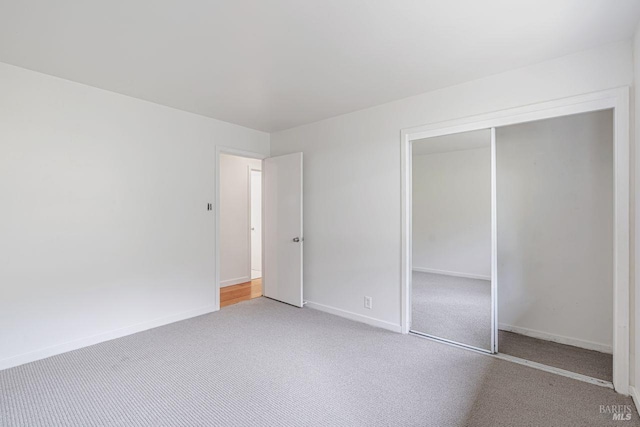 unfurnished bedroom with baseboards, a closet, and carpet floors