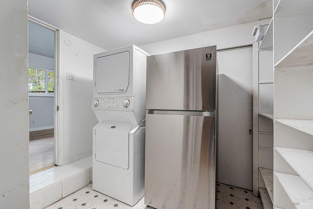 washroom with laundry area, light floors, and stacked washer / drying machine