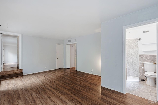 interior space featuring visible vents, baseboards, and wood finished floors