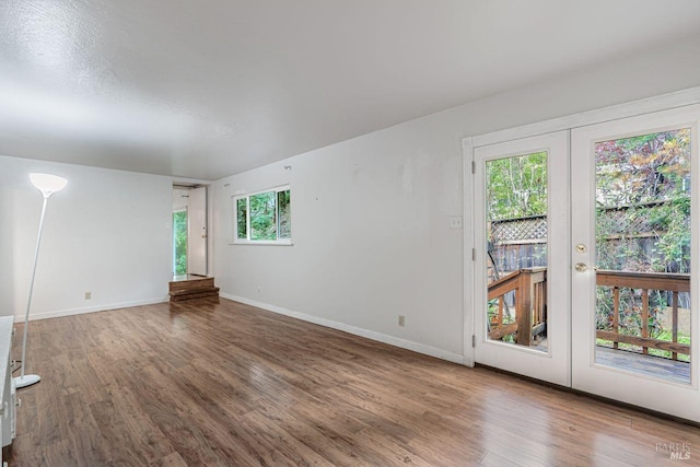 unfurnished room with wood finished floors, french doors, and baseboards