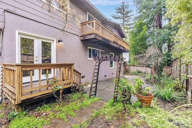 view of home's exterior featuring stucco siding, a fenced backyard, french doors, a balcony, and a patio area